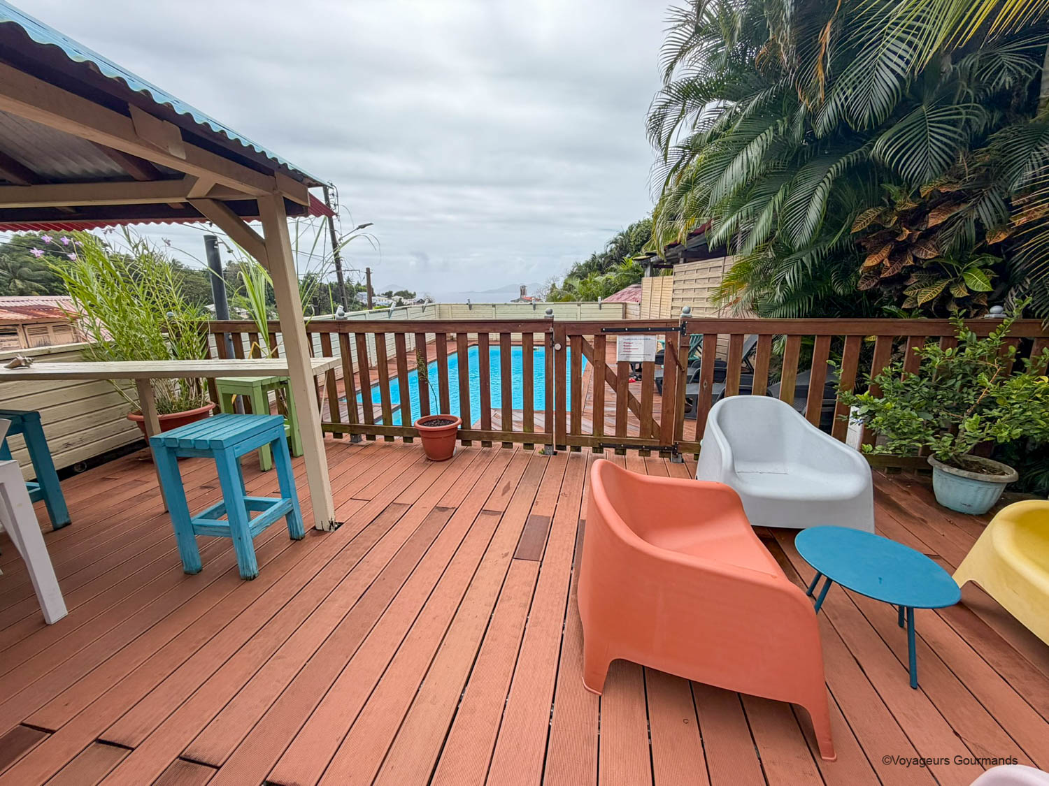 Terrasse en bois avec fauteuils colorés et piscine à Trois-Rivières