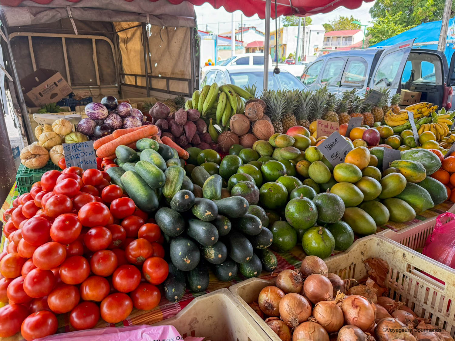 Étal de fruits et légumes tropicaux sur un marché en Guadeloupe