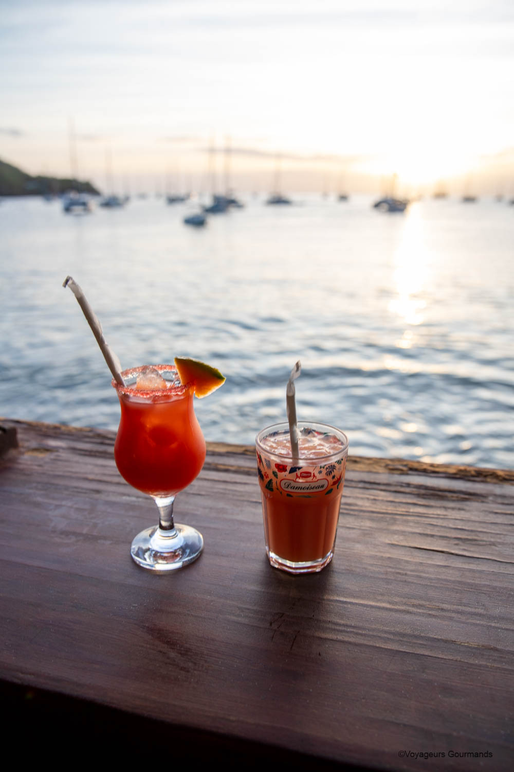 Cocktails face au coucher de soleil sur le port de Deshaies au restaurant La Croisière